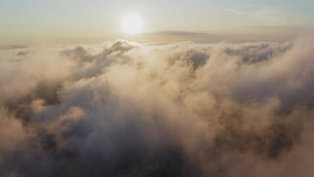 View from a drone of city center, above which clouds are rapidly floating