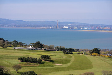 Beautiful scenic aerial-like bright view of gold course, sea, bay, Dublin Waste to Energy (Covanta...