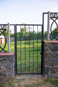 a black metal gate in a granite fence