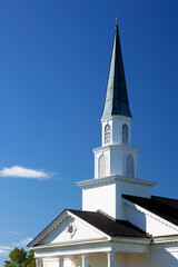 Closeup of white church steeple with blue sky
