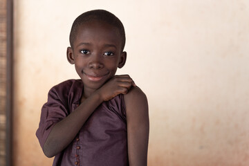 African black boy proudly shows his shoulder moments before getting the vaccine.