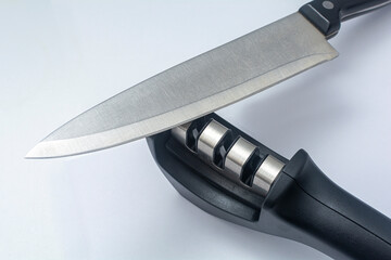 Knife - fillet knife and reversible manual knife sharpener. Items on a white background.