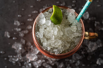 Moscow mule cocktail in copper cup with lime, ginger beer, vodka and mint garnish