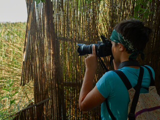 Caucasian girl photographing plant during forest excursion