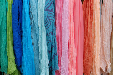 Background of many colorful pashmina scarves hanging