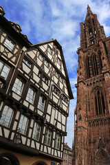 Strasbourg cathedral with a half-timbered house in the blue sky