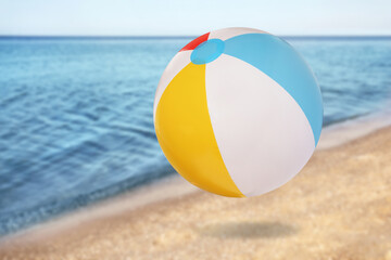 Fototapeta na wymiar Colorful inflatable beach ball and seascape on background