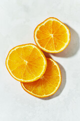 Macro view of an orange sliced into round slices on a white background.