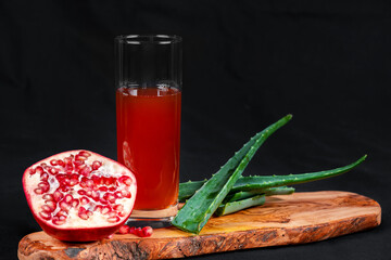 Leckerer Aloe-Vera-Granatapfel-Saft serviert auf einem Holzbrett