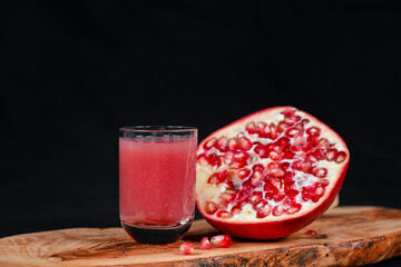 Leckerer Granatapfel-Drink serviert auf einem Holzbrett