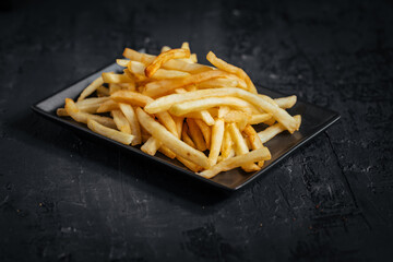 French fries with ketchup on a dark wooden rustic board