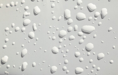 Fototapeta na wymiar White drops of water with shadows on a white background.