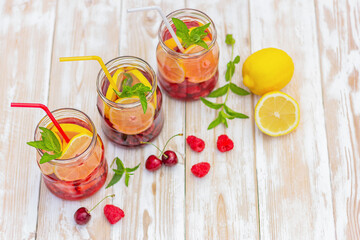 a drink made from lemon, strawberry, raspberry, cherry and mint. detox water. fruity citrus summer refreshing cocktail