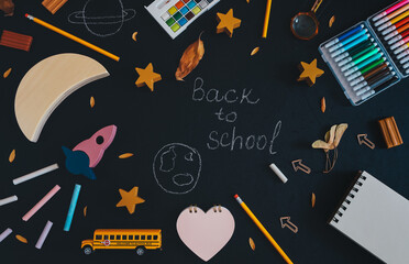 Rocket and school supplies.
Rocket, moon, stars, school bus, supplies and the inscription: Back to school on a black background with space for text in the middle, top view close-up.
