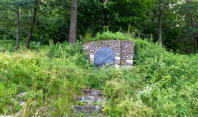 The cellar is made in the mountain. Entrance to the wine cellar with closed doors and stone stairs.