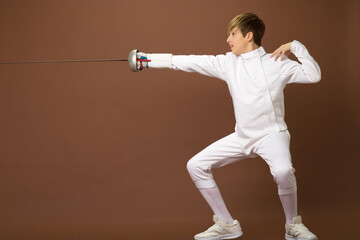 Boy fencer standing in attacking pose
