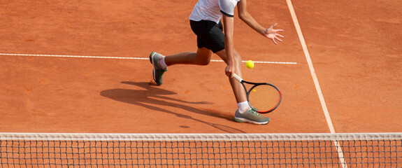 Male tennis player in action on the court on a sunny day. Professional sport concept. Horizontal...