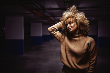 Portrait of rap girl posing in underground garage,