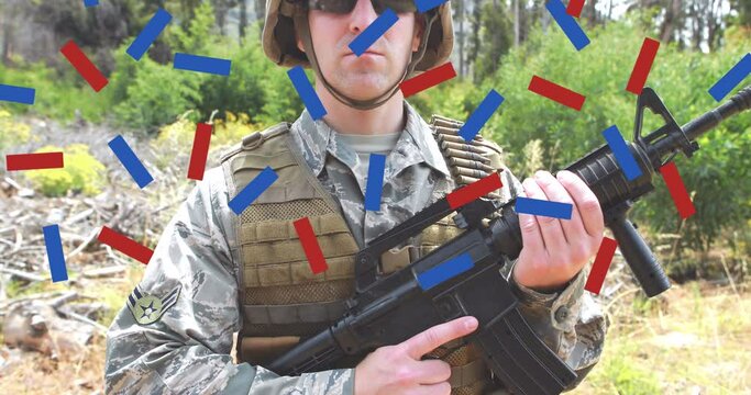 Composition of red and blue confetti, over male soldier in forest holding gun