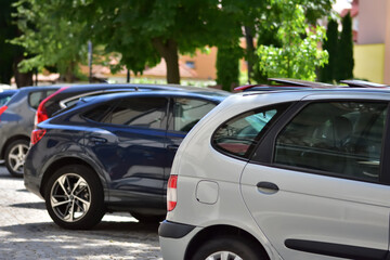 Cars and vehicles parked along the street on a sunny day. Summer. Sun.