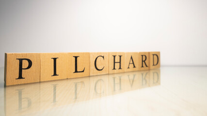 The name Pilchard was created from wooden letter cubes. Seafood and food.