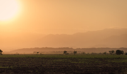Fototapeta na wymiar Sunset over fields and hills