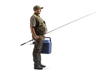 Full length profile shot of a fisherman holding a fishing rod and a portable fridge