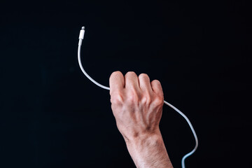 Top view of a person's hand holding a charger on a black surface