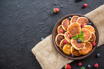 A healthy breakfast of cheese pancakes, berries, and honey. Creative atmospheric decoration