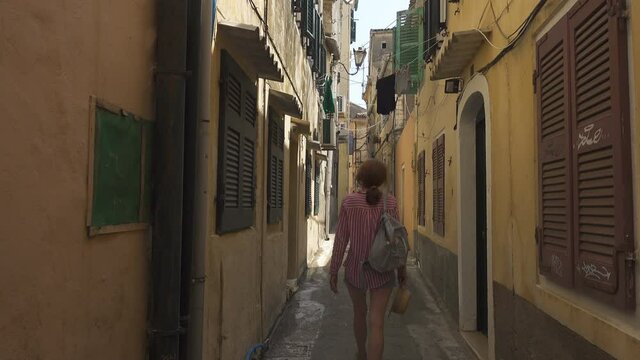 tourist woman walking by the streets of old city of Kerkyra Corfu island Greece
