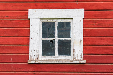 White framed window in a red barn.