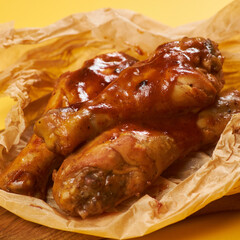 fried chicken legs on craft paper and yellow background