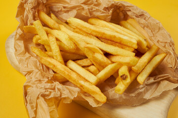 french fries on craft paper and yellow background