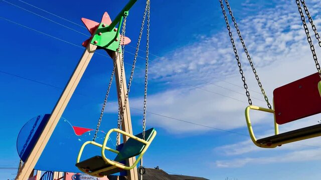 Swing in the playground. Swinging children's swing on the playground.