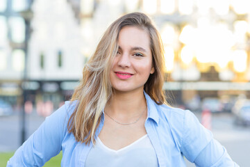 portrait of beautiful young woman near business center. attractive smiling girl, confident lady in the city outdoors. female student looking at the camera