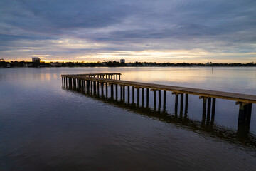 Fototapeta na wymiar The sun rises over a dock in the river in Florida
