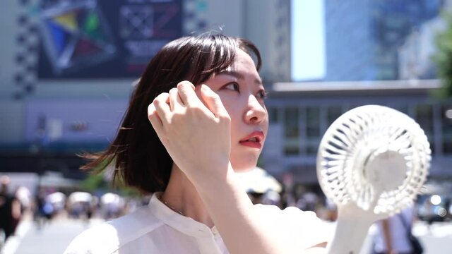 ハンディファンを使う女性