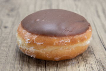 Custard raised donut is textured with chocolate coating for a sweet treat delight