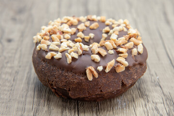 Chocolate raised donut is textured with crushed nut coating for a sweet treat delight