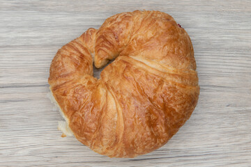 Overhead view of plain croissant roll is textured with flakey brust for a baked treat delight