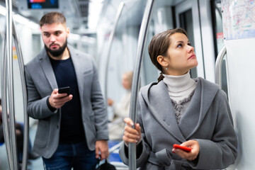 Woman with smartphone in subway car. High quality photo