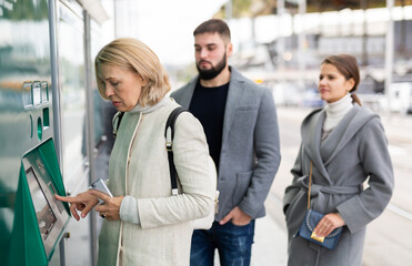 Fototapeta premium Woman traveler buying ticket at ticket vending machine.