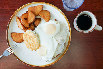 Fried eggs, biscuit and potatoes
