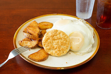 Fried eggs, biscuit and potatoes