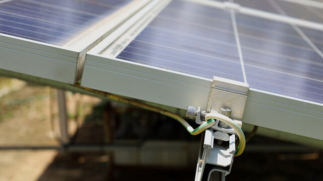 Ground wires on the solar panel. An overvoltage or lightning protection system is mounted beside the outdoor solar panel with a copy space. Select the focus close to the subject.