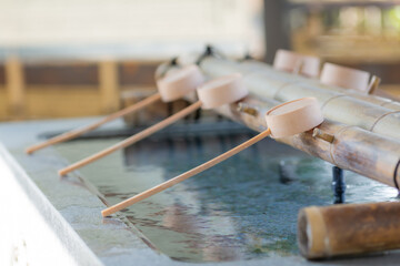 wooden ladles put on washbasin in suzuka shinto shrine in kanagawa, japan