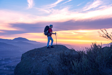latin hiker on the top of the mountain during the sunset