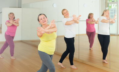 Fototapeta na wymiar Elderly women having dance training in studio, practicing active dances, healthy lifestyle