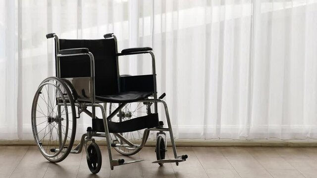 Panning technic video, wheelchair with nobody in the room with a white curtain in the background. Disable people and health care concept.
