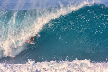 Surfing giant waves at Pipeline on the north shore of Hawaii